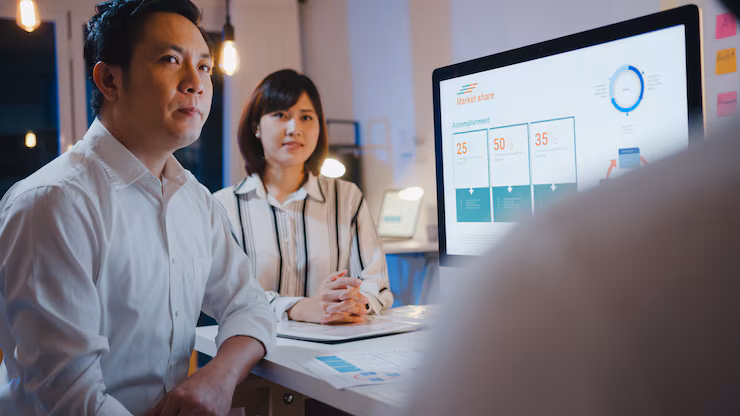 Executives viewing real-time charts and performance indicators on a digital analytics platform in a healthcare setting.